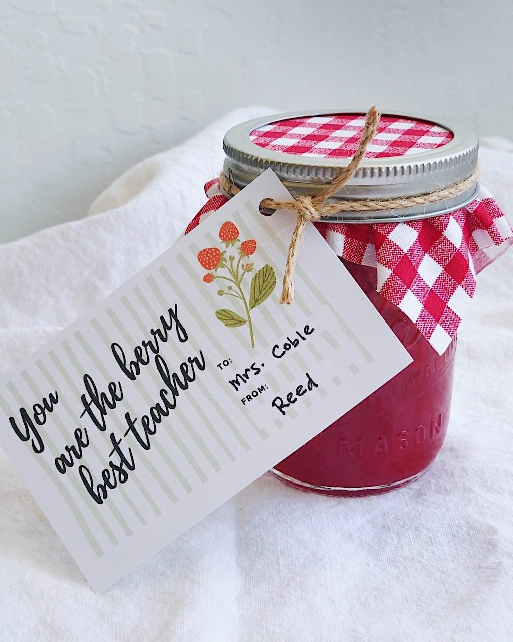 A jar of strawberry jam with a gift tag that says, "You are the berry best teacher."