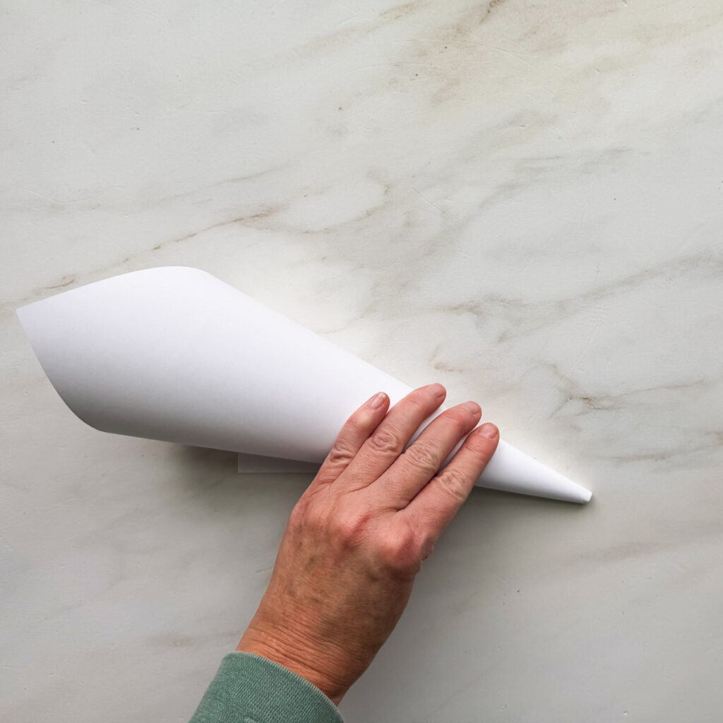 A white 8.5 by 11-inch piece of paper rolled up to a cone shape.