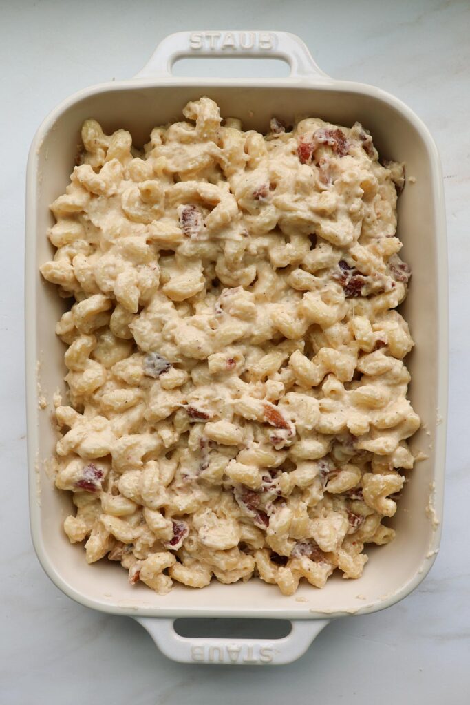 A white, 9 by 13-inch casserole dish filled with bacon mac and cheese.