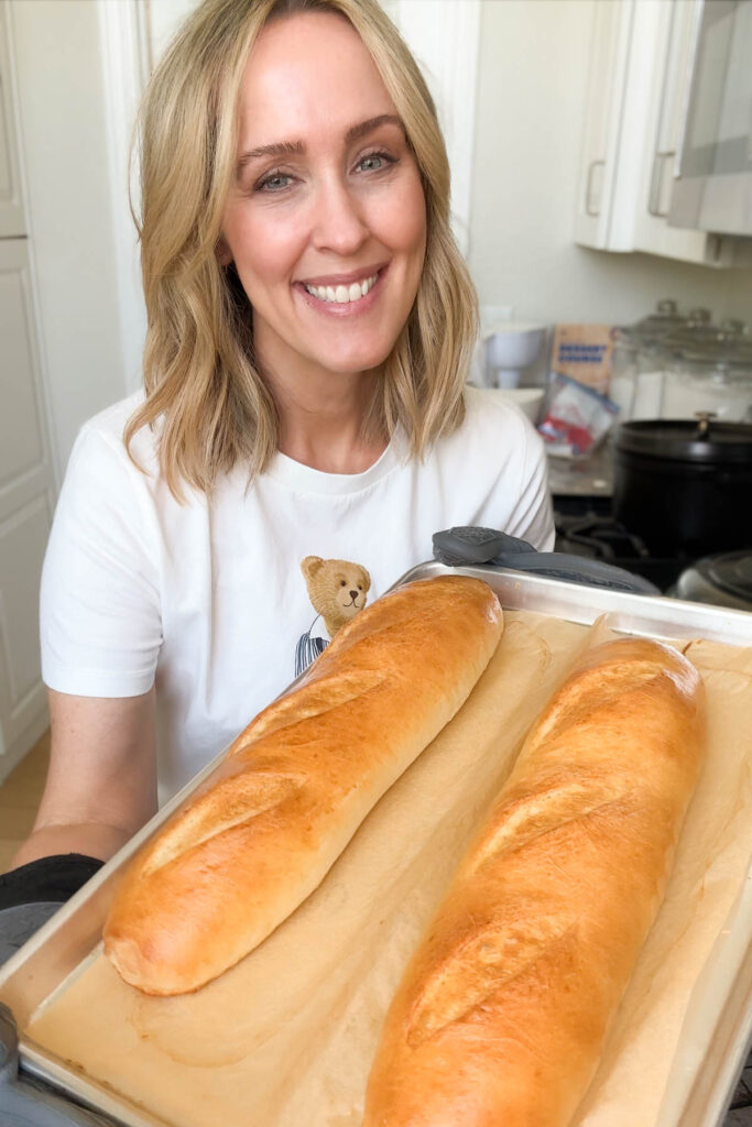 Heather holding a pan with french bread.