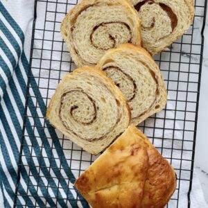 Cinnamon Swirl bread sliced on a cooling rack.