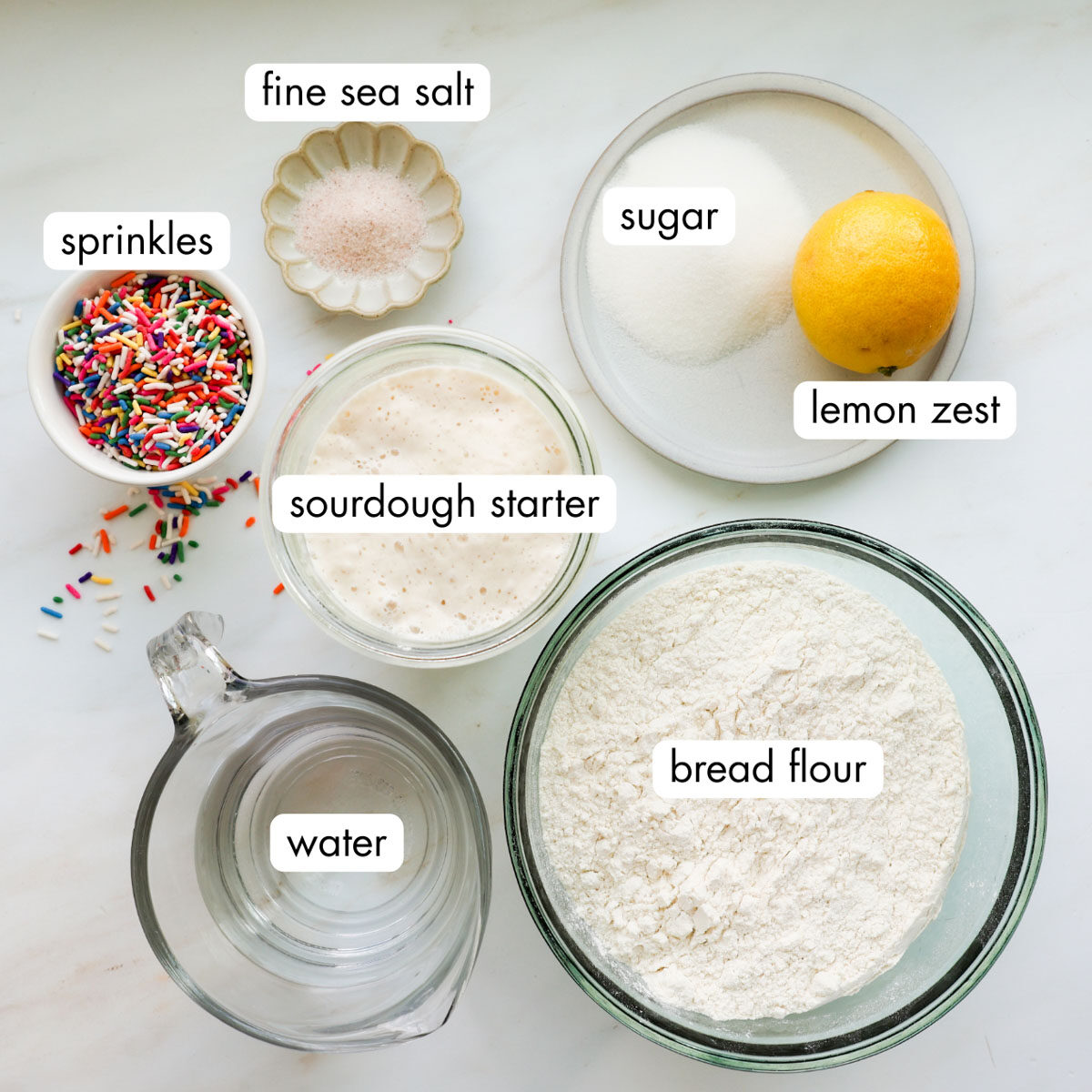 The ingredients for funfetti sourdough bread all measured out and each in their own bowl.