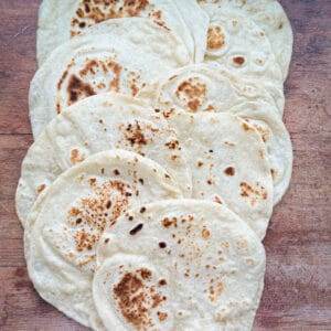 several flour tortillas spread out over a wooden countertop