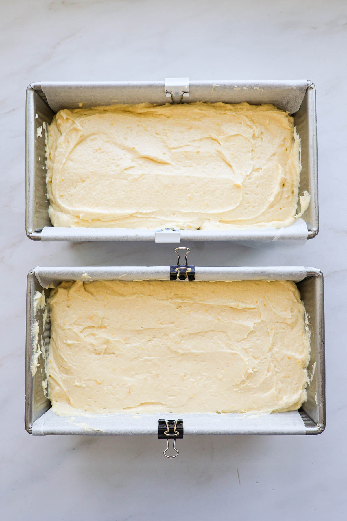Two loaves of lemon coconut bread in pans before being baked.