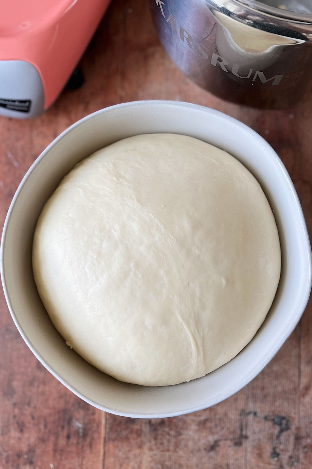 A bowl of roll dough rising to double in size.