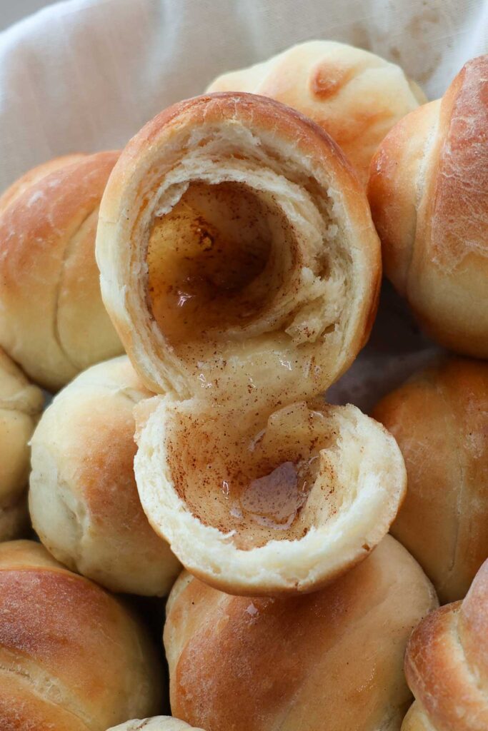 A resurrection roll split in half, showing the hollow inside with cinnamon sugar syrup.