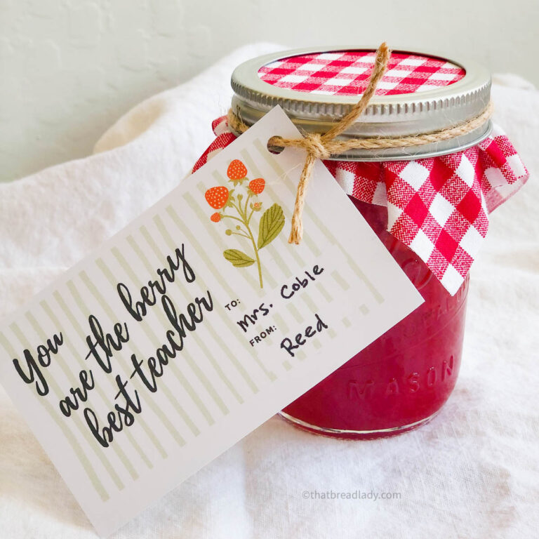 A jar of strawberry jam with a teacher appreciation gift tag tied to the lid.