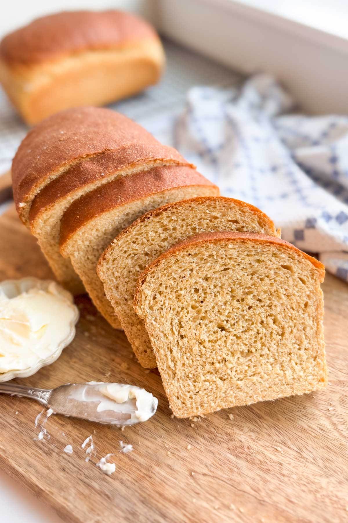 Honey Whole Wheat Sandwich Bread sliced on a wood bread board.