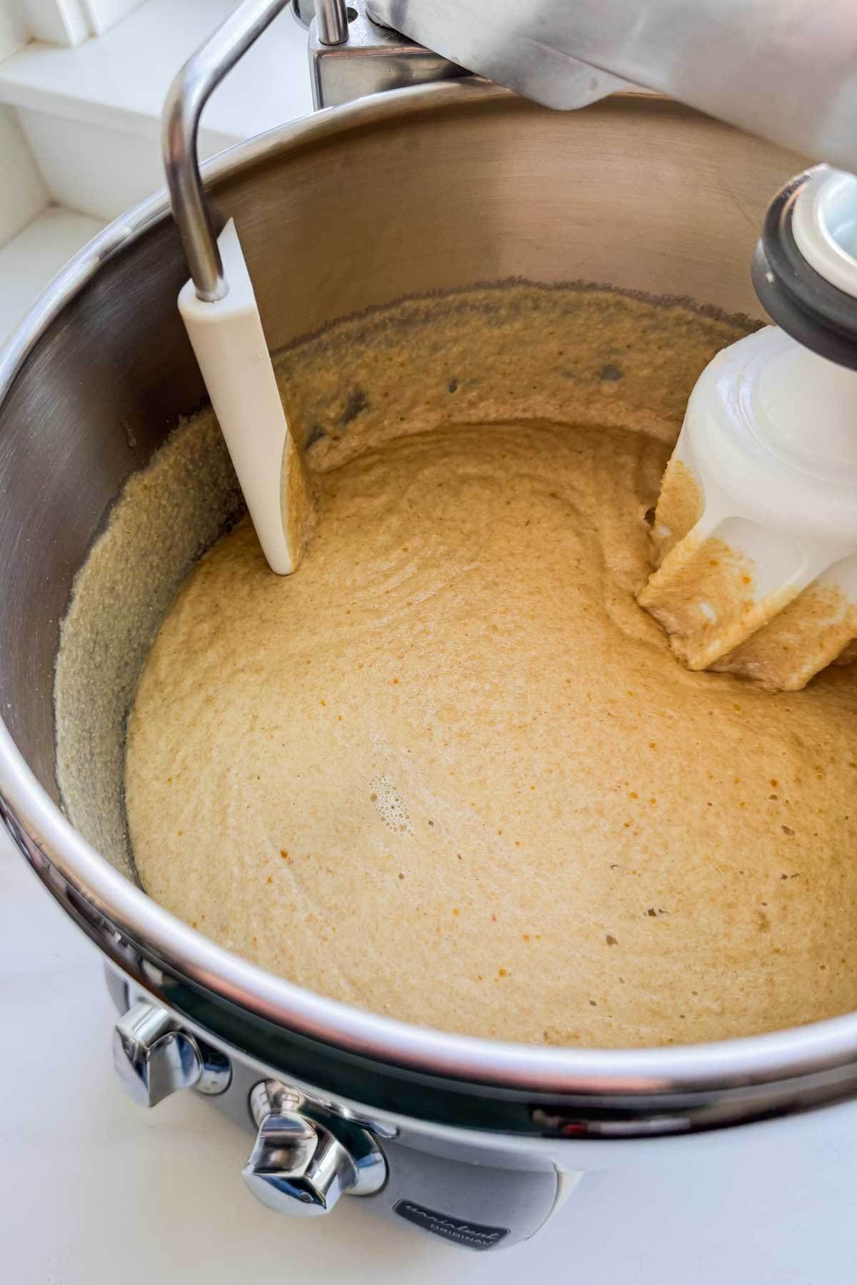 The sponge mixture for honey whole wheat bread in a mixer.