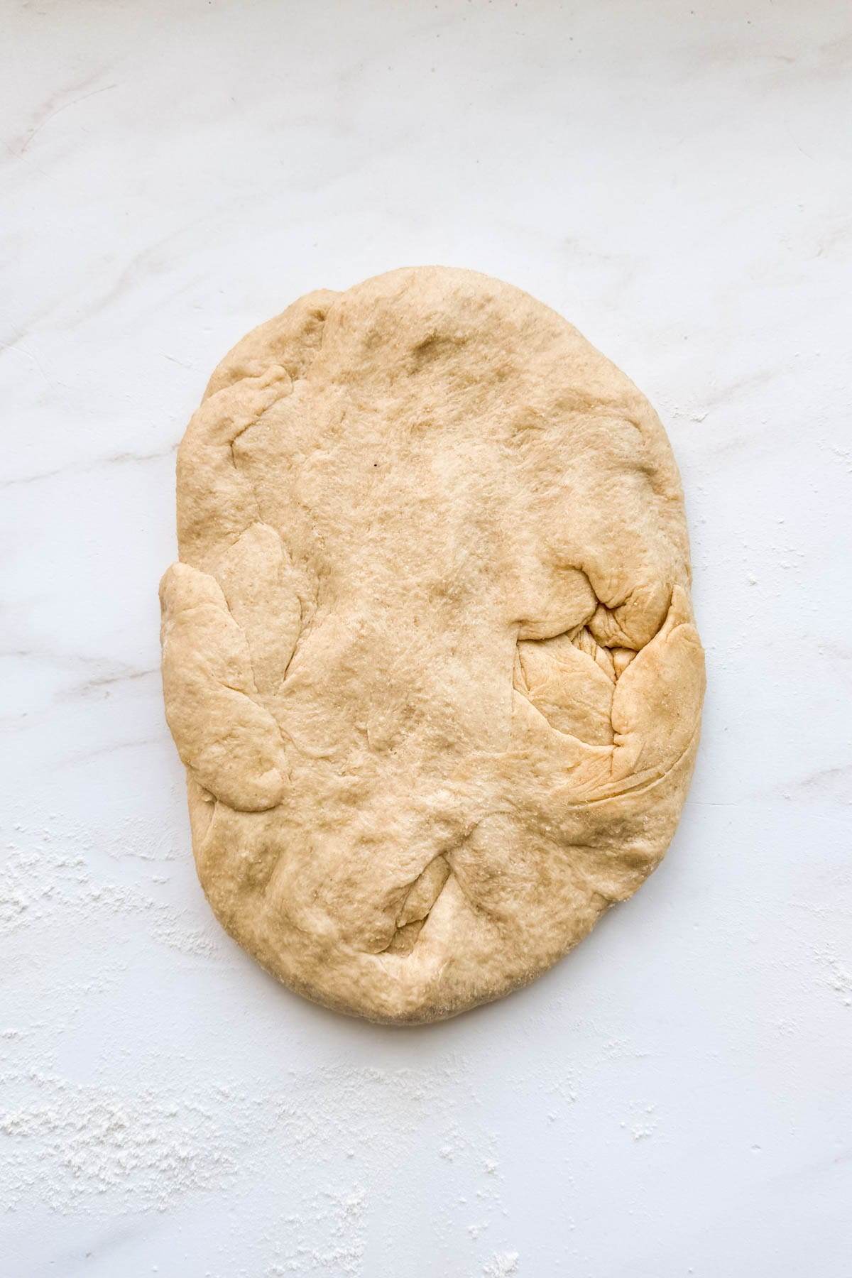 A flatten pieced of honey whole wheat bread dough.